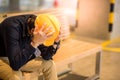 Young Asian engineer man feeling tried while sitting on bench Royalty Free Stock Photo