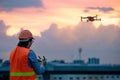 Young Asian engineer flying drone over construction site