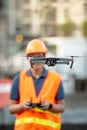 Young Asian engineer flying drone over construction site