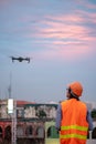 Young Asian engineer flying drone over construction site