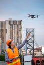 Young Asian engineer flying drone over construction site