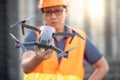 Young Asian engineer holding drone at construction site