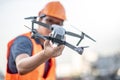 Young Asian engineer holding drone at construction site