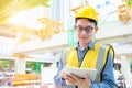 Young asian engineers are working on the construction site. Wear a yellow helmet safety and uniform staff. Hand holding smart