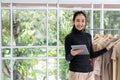 Young asian entrepreneur woman using tablet work at home office looking at camera with happy casual lifestyle.