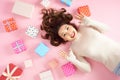 Young Asian excited woman lying on pink floor with many colorful gift boxes. Top view Royalty Free Stock Photo