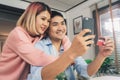 Asian family couple using smartphone discussing news or doing online shopping sitting together on desk at home. Royalty Free Stock Photo