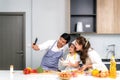 Young Asian family are preparing salad in the kitchen and father take a photo selfie by phone. Excited smiling and felling happy.