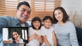 Young Asian family on video call, online remote meeting at home, look at camera. Internet communication information technology