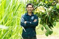 Young Asian farmer standing in organic mango farm Royalty Free Stock Photo