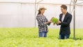 Young Asian farmer talking with young business man checking the quality of the agriculture