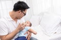 Young Asian Father spending time, take care of baby at home. Fatherhood, family concept Royalty Free Stock Photo