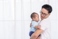 Young Asian Father spending time, take care of baby at home. Fatherhood, family concept Royalty Free Stock Photo