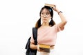 Young Asian female academic teen students with trendy eye glasses holding pile of books with bag isolated over white background. Royalty Free Stock Photo