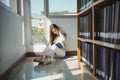 Young asian female college student sitting on floor in library, reading book Royalty Free Stock Photo