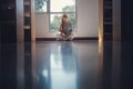 Young asian female college student sitting on floor in library, reading book Royalty Free Stock Photo