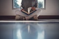 Young asian female college student sitting on floor in library, reading book Royalty Free Stock Photo