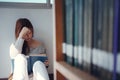 Young asian female college student sitting on floor in library, reading book Royalty Free Stock Photo