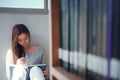 Young asian female college student sitting on floor in library, reading book Royalty Free Stock Photo