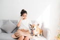Young Asian female crying on sofe with her Corgi dog