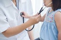 Female Doctor examining a little girl.