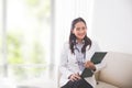 Young asian Female doctor, holding a clipboard and smiling to ca Royalty Free Stock Photo