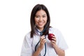 Young Asian female doctor listening to an apple with a stethoscope. Royalty Free Stock Photo