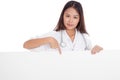 Young Asian female doctor point down to blank sign Royalty Free Stock Photo