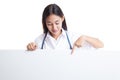 Young Asian female doctor point and look down to blank sign. Royalty Free Stock Photo