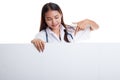 Young Asian female doctor point and look down to blank sign. Royalty Free Stock Photo