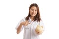 Young Asian female doctor point to a pig bank coin. Royalty Free Stock Photo