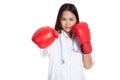 Young Asian female doctor punch with boxing glove Royalty Free Stock Photo