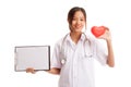 Young Asian female doctor with red heart and blank clipboard Royalty Free Stock Photo