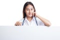 Young Asian female doctor standing behind blank white billboard. Royalty Free Stock Photo