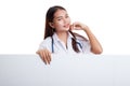 Young Asian female doctor standing behind blank white billboard. Royalty Free Stock Photo