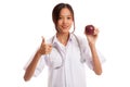 Young Asian female doctor thumbs up with apple Royalty Free Stock Photo