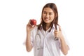 Young Asian female doctor thumbs up with apple. Royalty Free Stock Photo