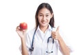 Young Asian female doctor thumbs up with apple. Royalty Free Stock Photo