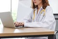 Young Asian female doctor using computer laptop on the desk in hospital office. Royalty Free Stock Photo