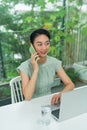 Young Asian female entrepreneur talking on the phone while working at the home office Royalty Free Stock Photo