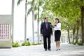 Young Asian female executive and senior businessman walking together Royalty Free Stock Photo