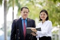 Young Asian female executive and senior businessman walking together Royalty Free Stock Photo