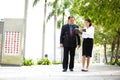 Young Asian female executive and senior businessman walking together Royalty Free Stock Photo