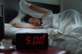 Young asian female getting stressed waking up early in the morning at 5 o`clock,Alarm clock