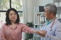 A young Asian female patient is being examined by a medical professional, A dignified middle-aged male doctor is diagnosing a