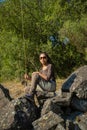 A young asian female sitting on a rock in the river while fly fishing Royalty Free Stock Photo