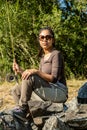 A young asian female sitting on a rock in the river while fly fishing Royalty Free Stock Photo