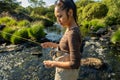 A young asian female standing fly fishing in a riffle on a river Royalty Free Stock Photo