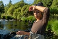 A young asian female standing fly fishing in a riffle on a river Royalty Free Stock Photo