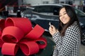 Young asian female stands with car keys